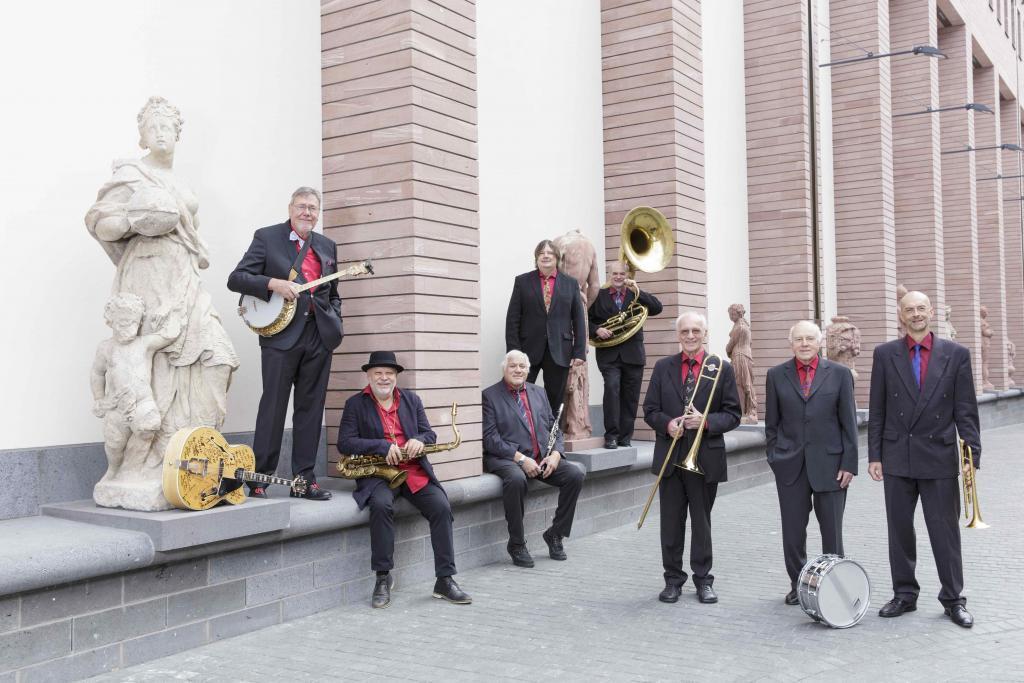 HMF Allstars mit Instrumenten vor einer Skulptur auf dem Vorplatz des Historischen Museums